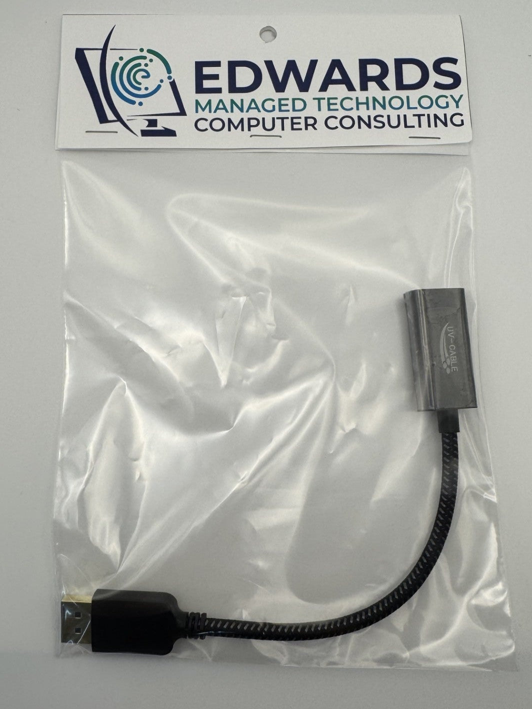 Black adapter cable in a clear plastic bag with Edwards Managed Technology Computer Consulting label on a white background